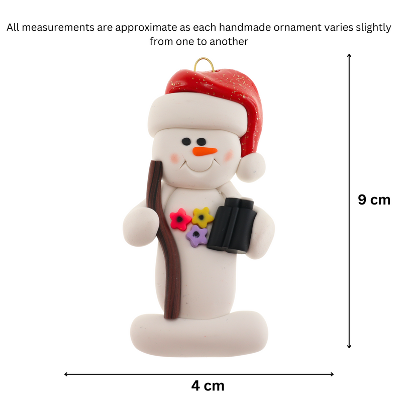 Snowman in red hat holding walking stick and binoculars, graphed to show size (4x9cm).