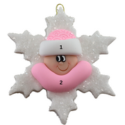Baby ornament with infant face and pink hat on glittery white snowflake base, numbered 1-2 for personalization.