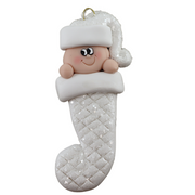 Ornament with infant head in a white glitter hat poking out of a white glitter stocking.