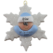 Baby ornament with infant face and blue hat on glittery white snowflake base, personalized with name.