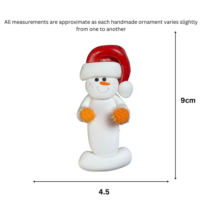 Ornament of white snowman in red hat holding orange cheerleader pom-poms, graphed to show size (4.5x9cm).