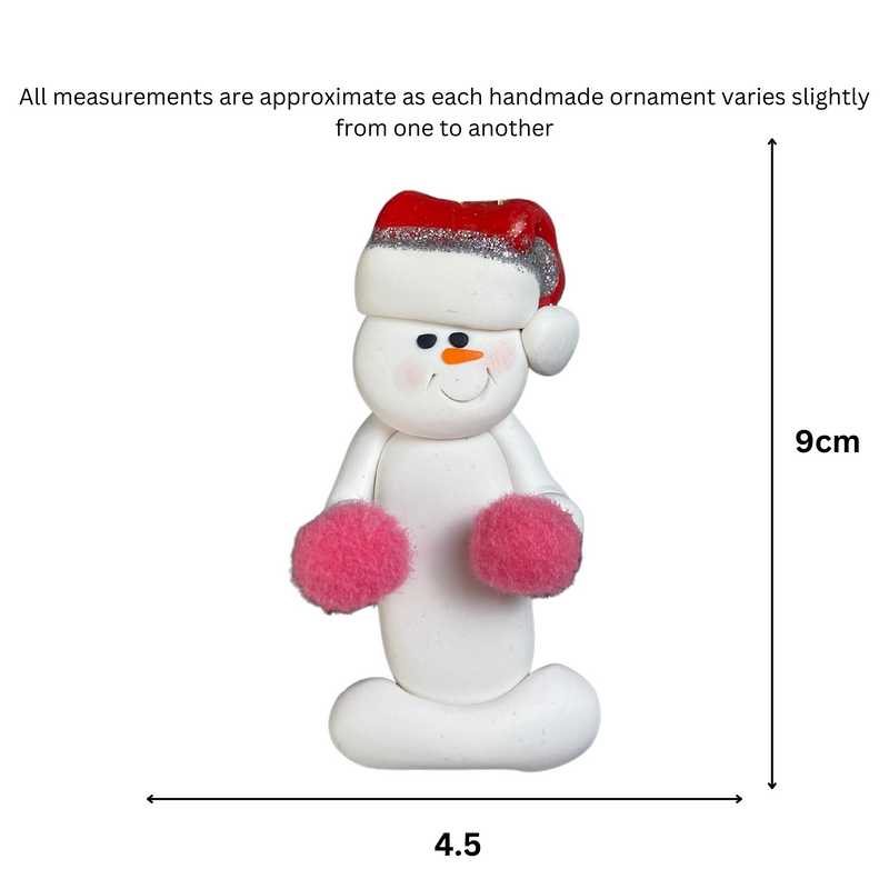 Ornament of white snowman in red hat holding pink cheerleader pom-poms, graphed to show size (4.5x9cm).
