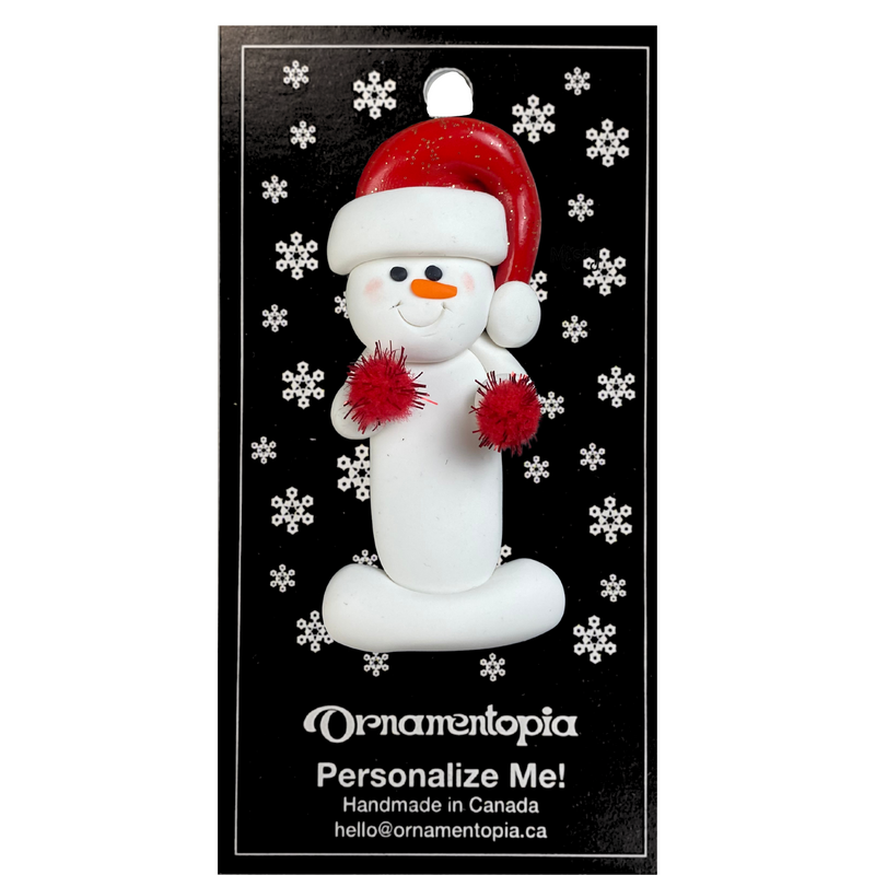 Ornament of white snowman in red hat holding red cheerleader pom-poms, on display backing card.