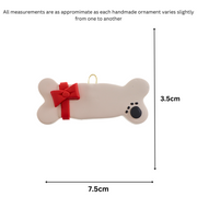 Ornament of dog bone with ribbon and paw print, graphed to show size (7.5x3.5cm).