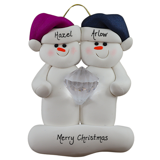 A couple’s ornament of two white snowmen holding a plastic diamond, personalized with names.