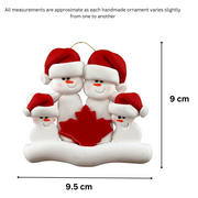 Family ornament with 4 white snowmen in red hats, gathered around a red maple leaf, graphed to show size (9.5x9cm).