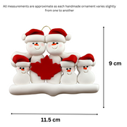 Family ornament with 5 white snowmen in red hats, gathered around a red maple leaf, graphed to show size (11.5x9cm).