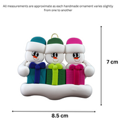 Family ornament with 3 white snowmen in colourful hats holding matching presents, graphed to show size (8.5x7cm).