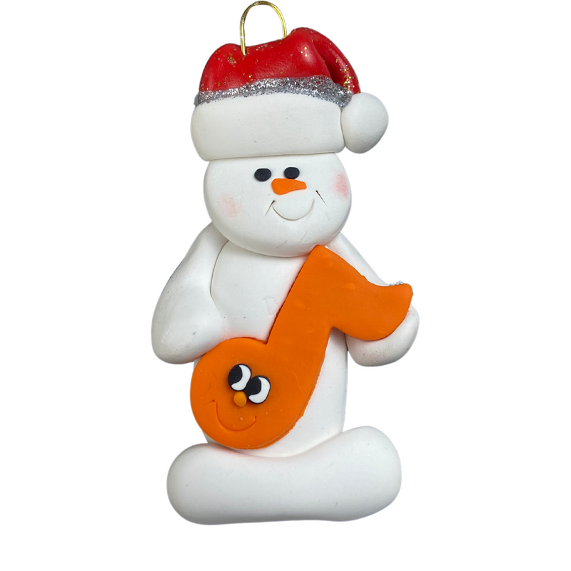 Ornament of white snowman in red hat holding an orange music note.