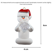 Ornament of white snowman in red hat holding large plastic diamond, graphed to show size (4x9cm).