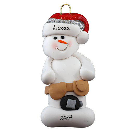 Ornament of white snowman in red hat wearing tool belt with tape measure, personalized with name.
