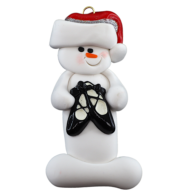 Ornament of white snowman in red hat holding black ballet shoes.