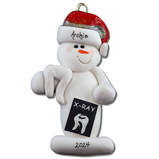 Ornament of white snowman in red hat holding dental x-ray and white tooth, personalized with name.