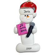 Ornament of white snowman in red hat holding a microphone and pink music book, personalized with name.