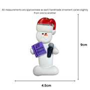 Ornament of white snowman in red hat holding a microphone and purple music book, graphed to show size (4.5x9cm).