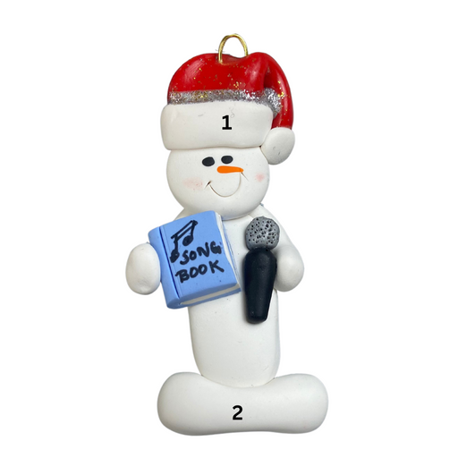 Ornament of white snowman in red hat holding a microphone and blue music book, numbered 1-2 for personalization.