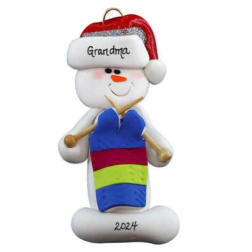 Ornament of white snowman in red hat holding an in-progress knitting project on knitting needles, numbered 1-2 for personalization.