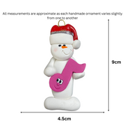 Ornament of white snowman in red hat holding a pink music note, graphed to show size (4.5x9cm).