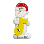 Ornament of white snowman in red hat holding a yellow music note, personalized with name.