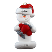 Ornament of white snowman in red hat holding a red airplane, personalized with name.