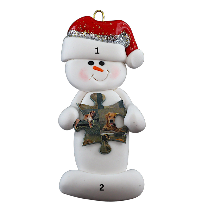 Ornament of white snowman in red hat holding a puzzle piece, numbered 1-2 for personalization.