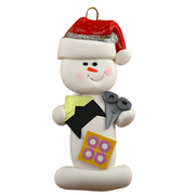 Ornament of white snowman in red hat holding a pair of scissors and various scrapbooking papers.