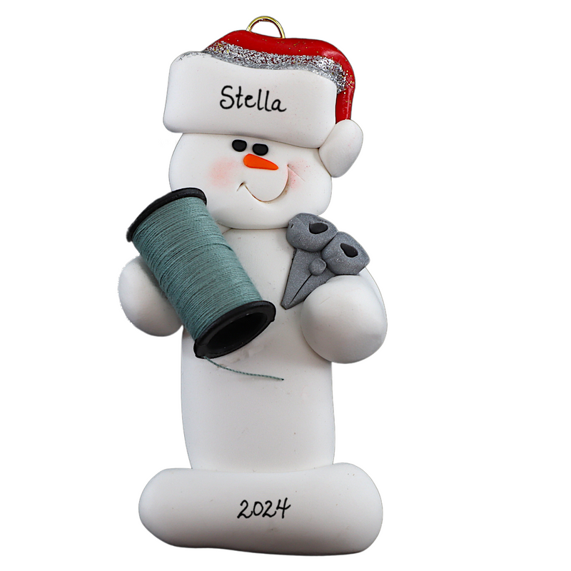 Ornament of white snowman in red hat holding a spool of thread and scissors, numbered 1-2 for personalization.