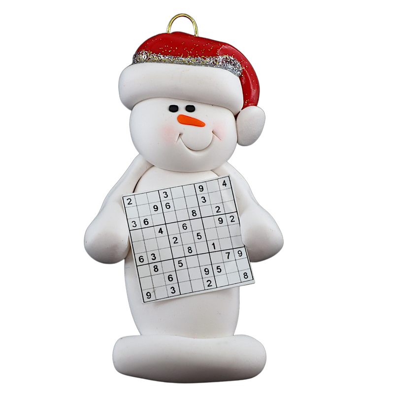 Ornament of white snowman in red hat holding a sudoku page.
