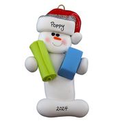 Ornament of white snowman in red hat holding vibrant yoga mat and block, personalized with name.