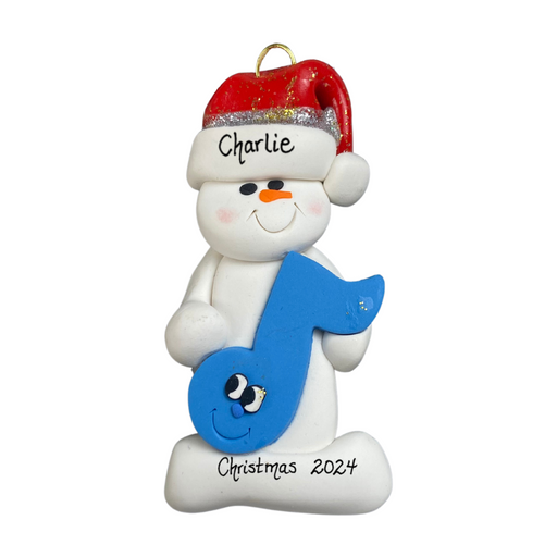 Ornament of white snowman in red hat holding a blue music note, personalized with name.
