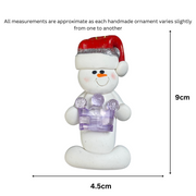 Ornament of white snowman in red hat holding purple plastic crown, graphed to show size (4.5x9cm).