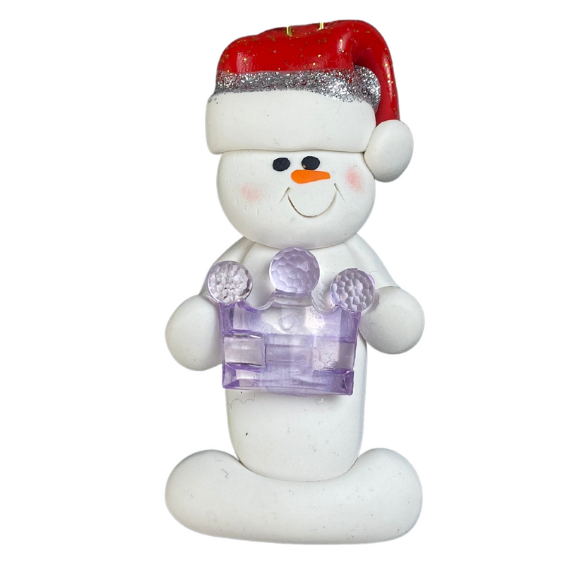 Ornament of white snowman in red hat holding purple plastic crown.