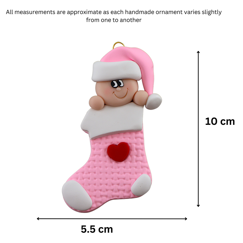 Ornament with infant head in a pink hat poking out of a pink stocking, graphed to show size (5.5x10cm).