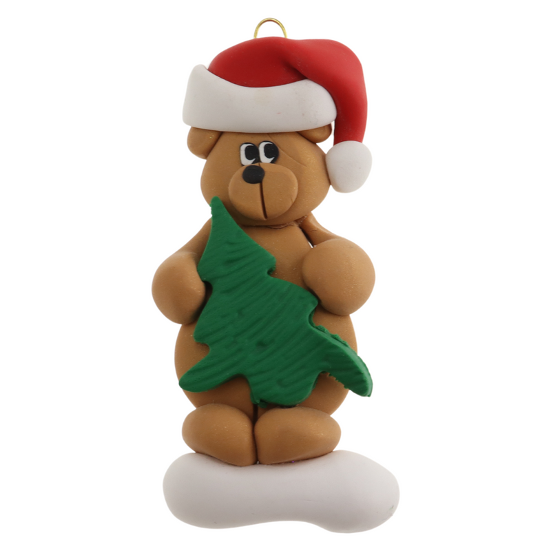 Tan bear in red festive hat holding green tree ornament.