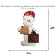 Ornament of white snowman in red hat holding briefcase and files, graphed to show size (5x11cm).