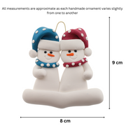 A couple’s ornament of two white snowmen in polka dot scarves and hats, graphed to show size (8x9cm).