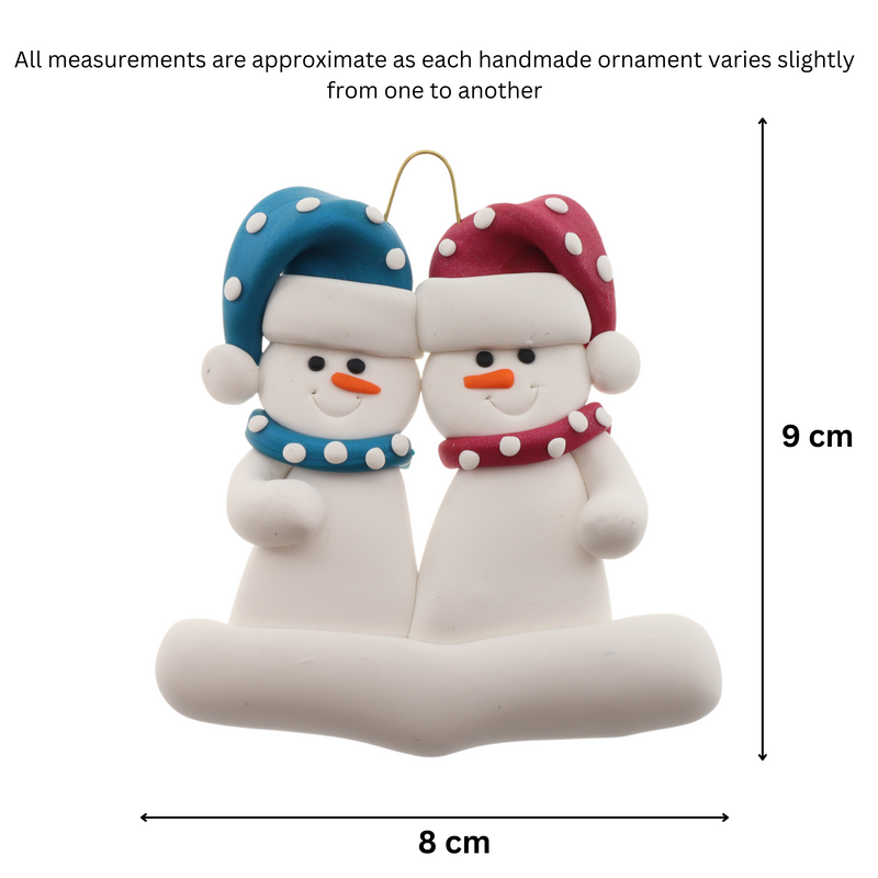 A couple’s ornament of two white snowmen in polka dot scarves and hats, graphed to show size (8x9cm).