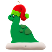 Green dinosaur wearing red festive hat ornament, numbered 1-2 for personalization.