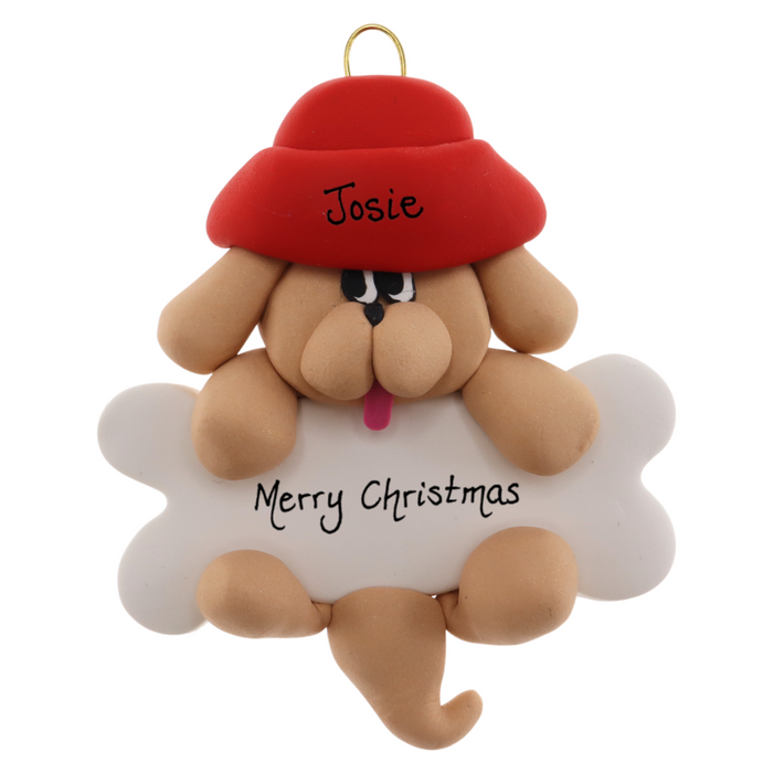 Ornament of tan dog in red hat hanging on a white bone, personalized with names.