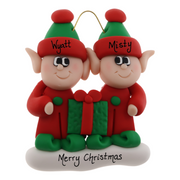 A couple’s ornament with two small red and green elves with a matching present, personalized with names.