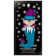 Elf poking out of blue stocking ornament, on display backing card.