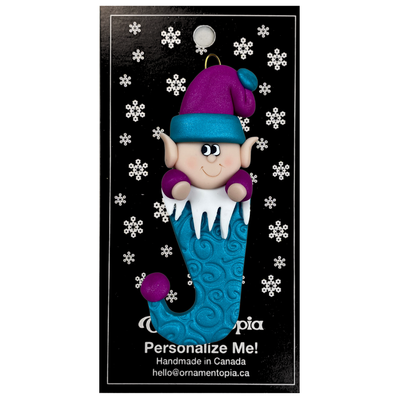 Elf poking out of blue stocking ornament, on display backing card.