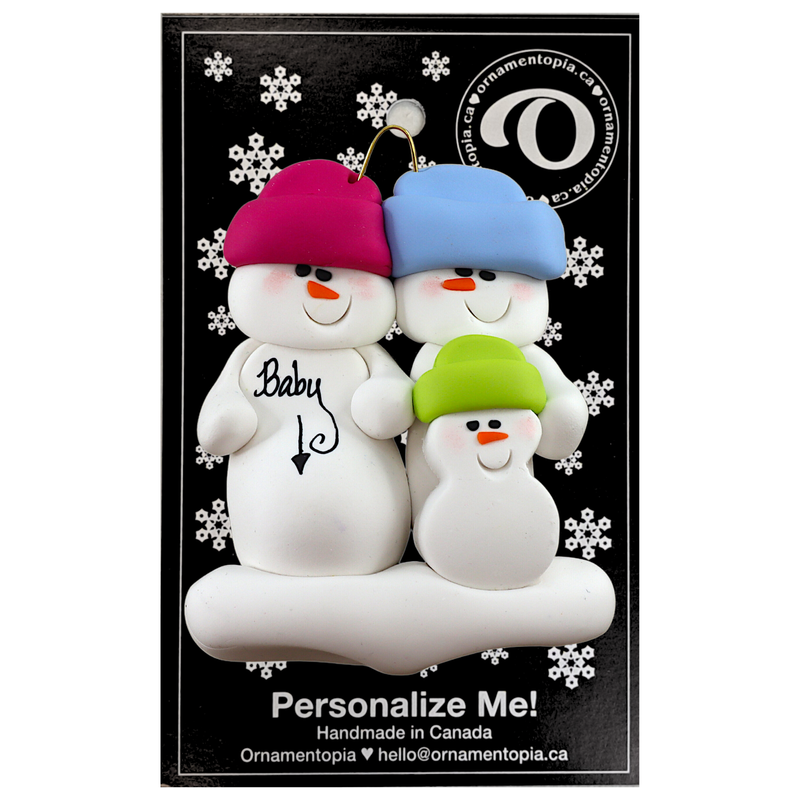 Family ornament with 3 snowmen in bright hats, one pregnant, on display backing card.