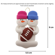 Family ornament with 2 white snowmen in bright hats with a football, graphed to show size (5.5x9cm).