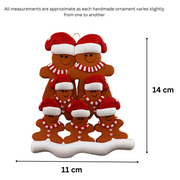 Family ornament with 7 brown gingerbread figures in red Christmas hats, graphed to show size (11x14cm).