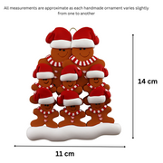 Family ornament with 8 brown gingerbread figures in red Christmas hats, graphed to show size (11x14cm).