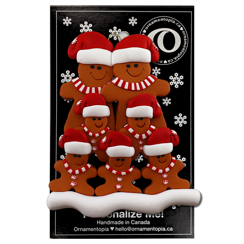 Family ornament with 7 brown gingerbread figures in red Christmas hats, on display backing card.