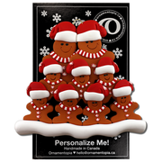 Family ornament with 9 brown gingerbread figures in red Christmas hats, on display backing card.