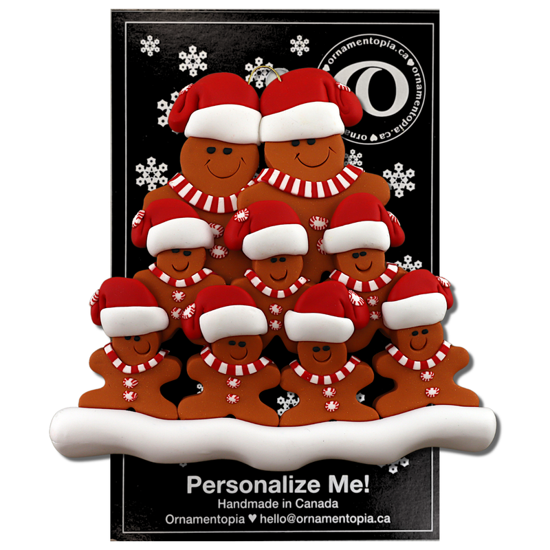Family ornament with 9 brown gingerbread figures in red Christmas hats, on display backing card.