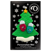 Christmas tree ornament decorated with 2 light bulbs with smiling faces, on display backing card.